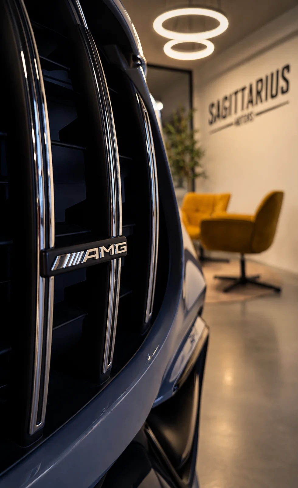 Mercedes-AMG Kühlergrill mit dem Showroom von Sagittarius Motors im Hintergrund